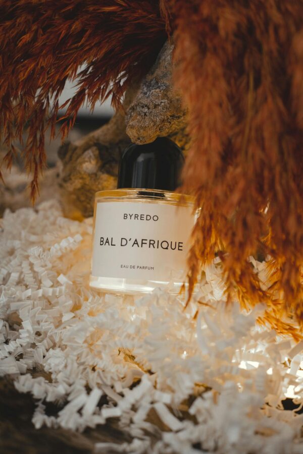 Elegant Byredo Bal d'Afrique perfume enveloped in a luxurious feather setting.