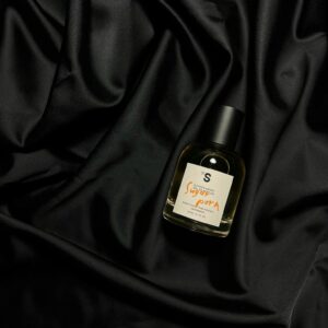 Stylish perfume bottle displayed on luxurious black silk fabric, perfect for fashion themes.