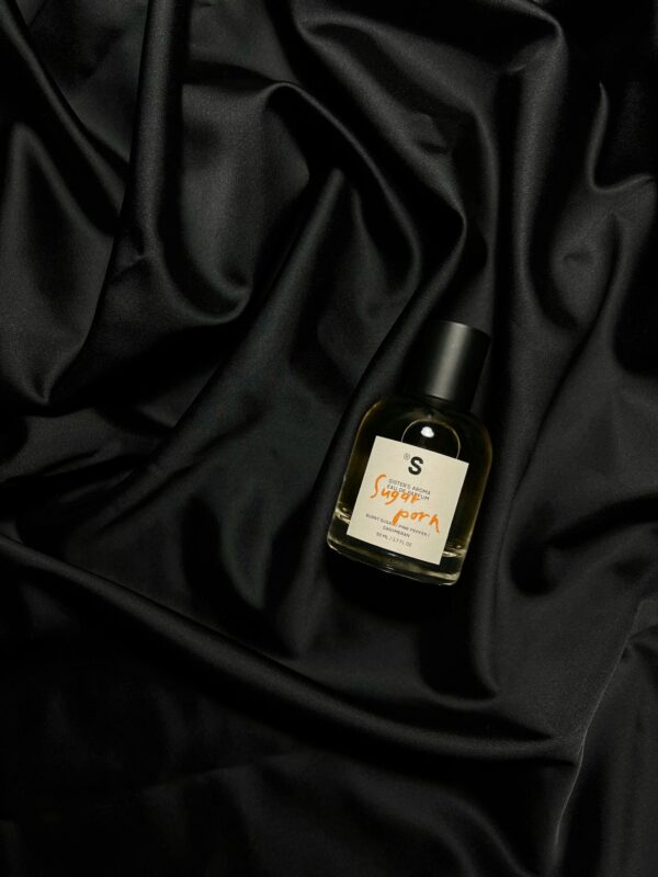 Stylish perfume bottle displayed on luxurious black silk fabric, perfect for fashion themes.